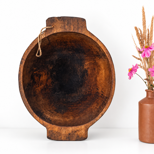 Antique European round wooden dough bowl with dark brown patina, rustic handles and aged interior, ideal for farmhouse table or wall decor