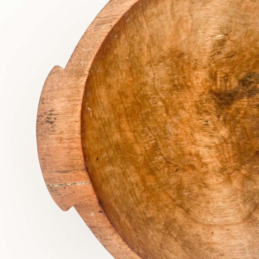 Traditional hand-carved wooden bread dough bowl from the 1920s, featuring a round shape and unique signs of age and wear.