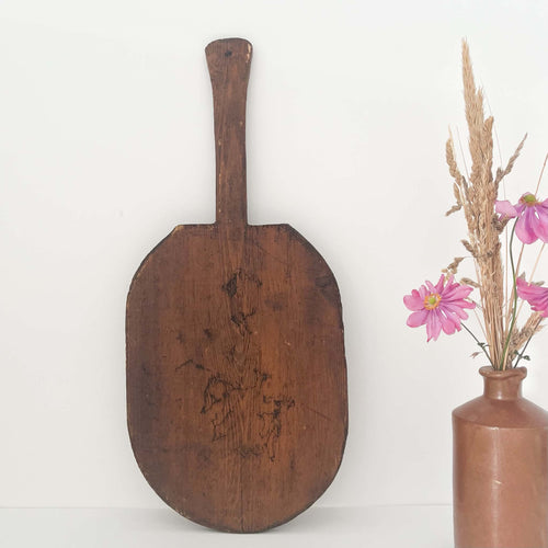 Antique oval wooden bread board with a long handle, hand-carved from solid wood with beautiful rustic patina and aged character
