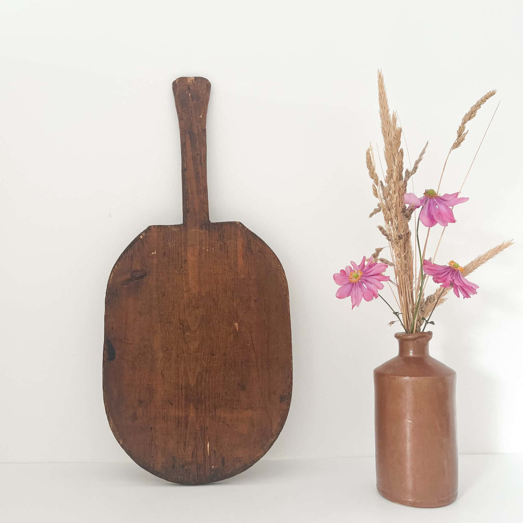 Hand-carved antique wooden baker's peel made from a single piece of solid wood with an oval board and extended handle